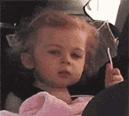 Toddler in a car seat giving a flat, unimpressed side glance