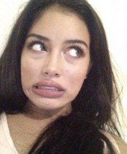 Woman with eyes rolled back and lip curled in an exaggerated cringing, disgusted face
