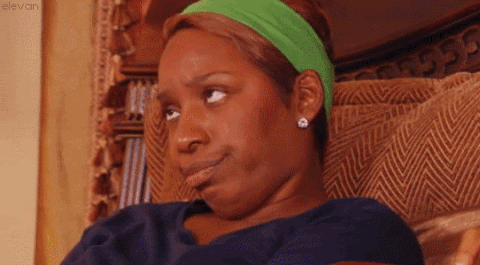 Woman in a green headband cutting a slow, unimpressed side-eye