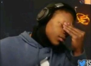 Person in headphones pressing their hand over their face in a full facepalm moment