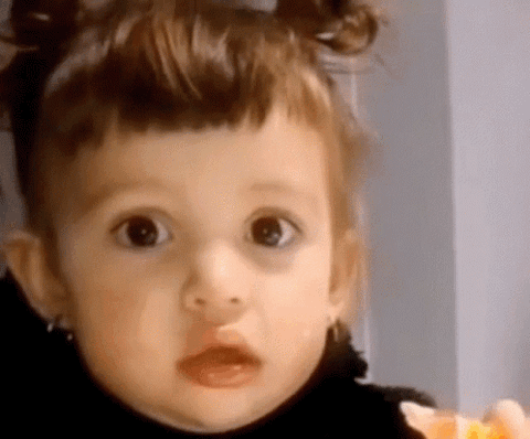 Toddler with a puffy-lipped blank stare, looking mildly unimpressed