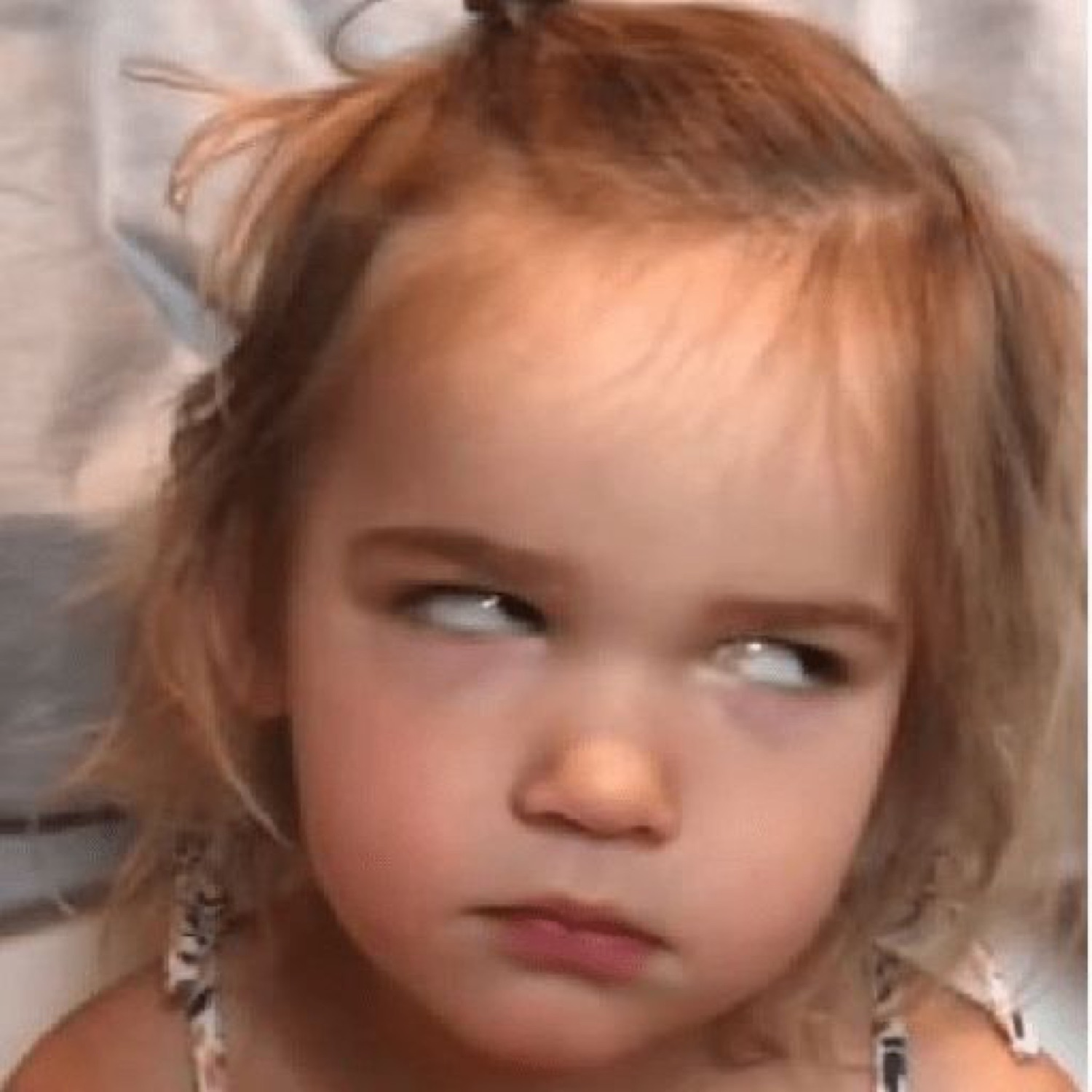 Toddler girl giving an extreme side-eye with total disdain, not impressed at all