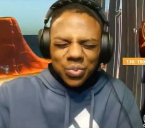 Guy in headphones squinting with a sour, cringing face during a stream