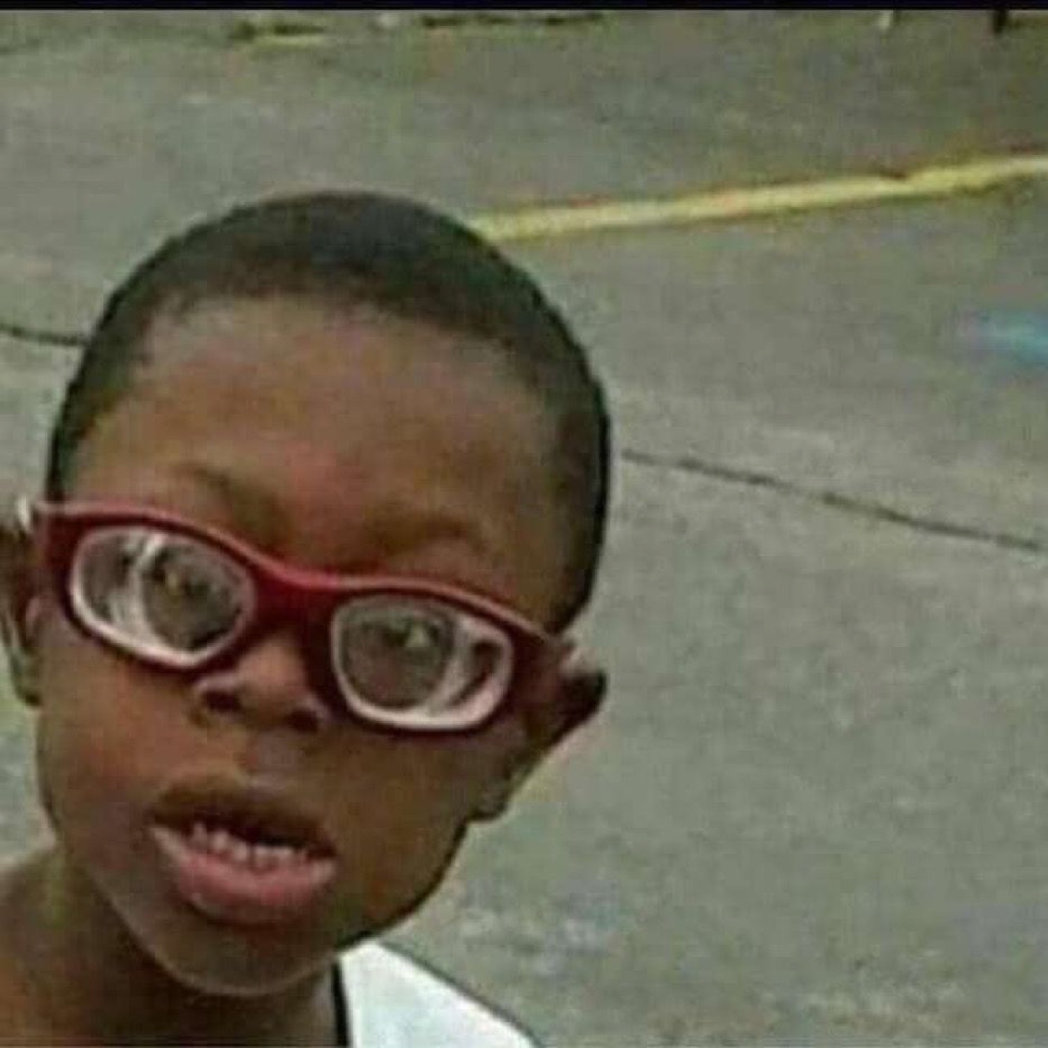 Kid in red glasses giving a bewildered side-eyed look at the camera