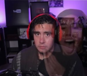 Gamer with red headphones staring blankly forward with a ghost of his screaming face beside him