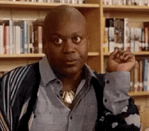 Man in a library raising his eyebrows in wide-eyed shocked disbelief