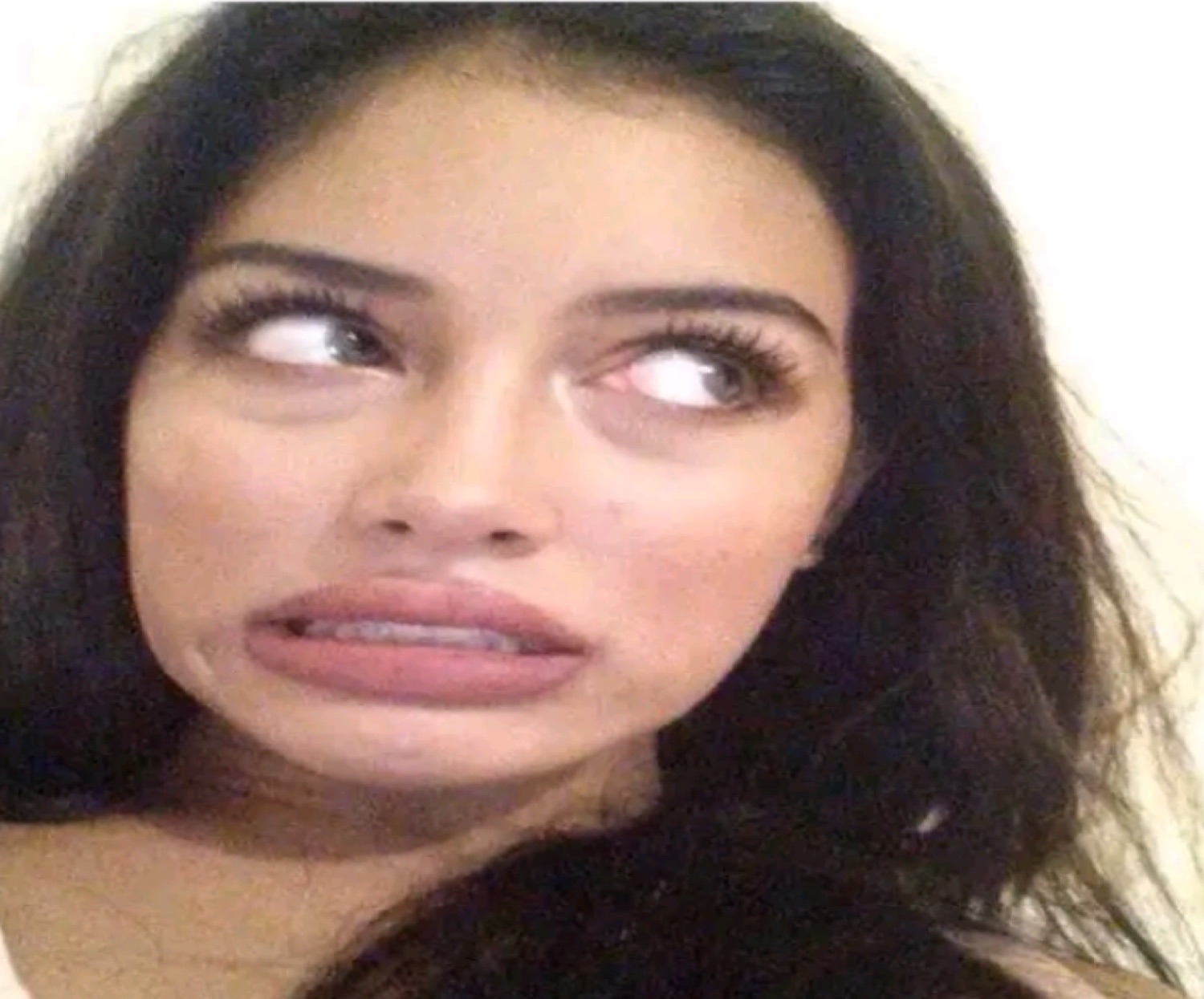 Woman rolling her eyes up with a cringing, disgusted grimace