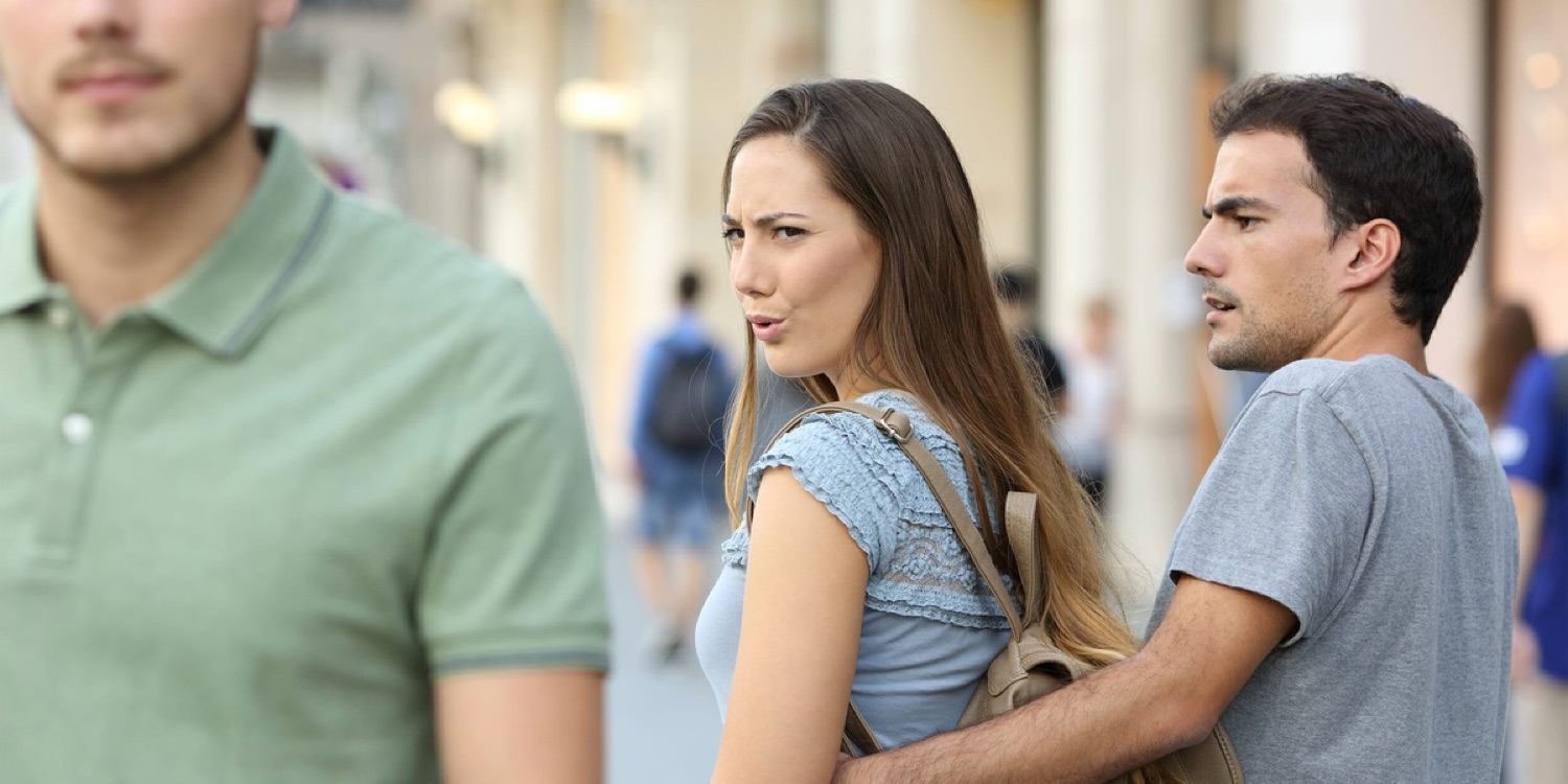 Woman turning back to side-eye someone while her boyfriend looks on, unbothered