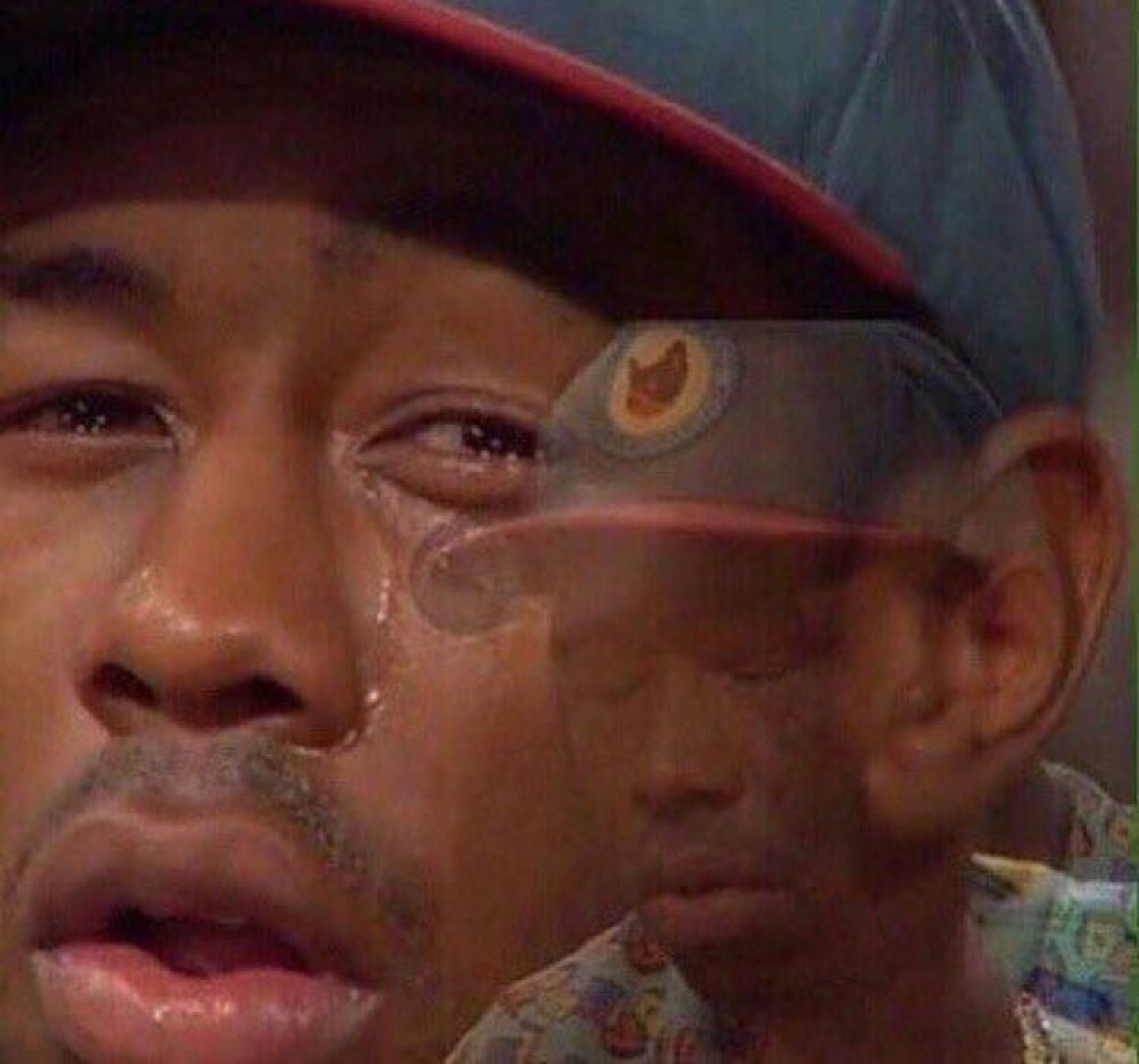 Blurry double-exposed man in a cap crying with tears streaming down his face