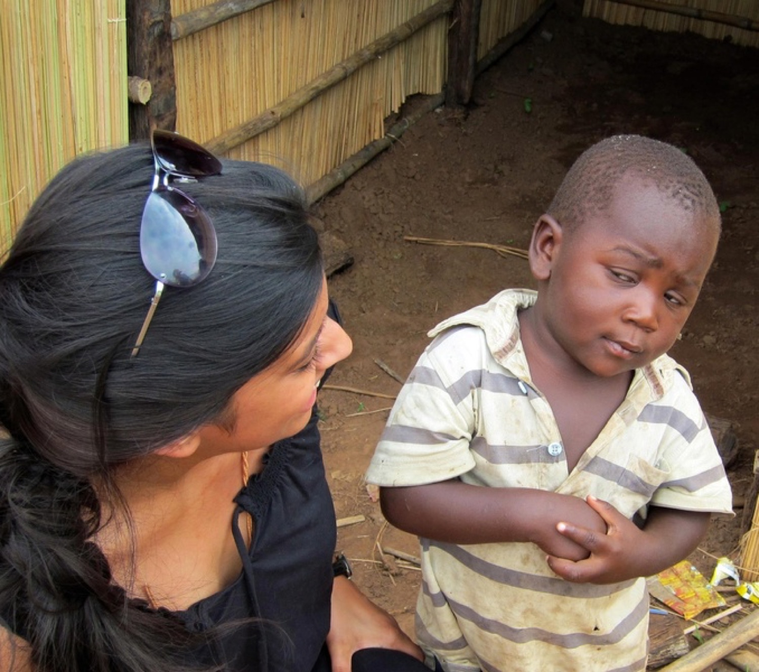 Little kid squinting skeptically at a woman crouched beside him