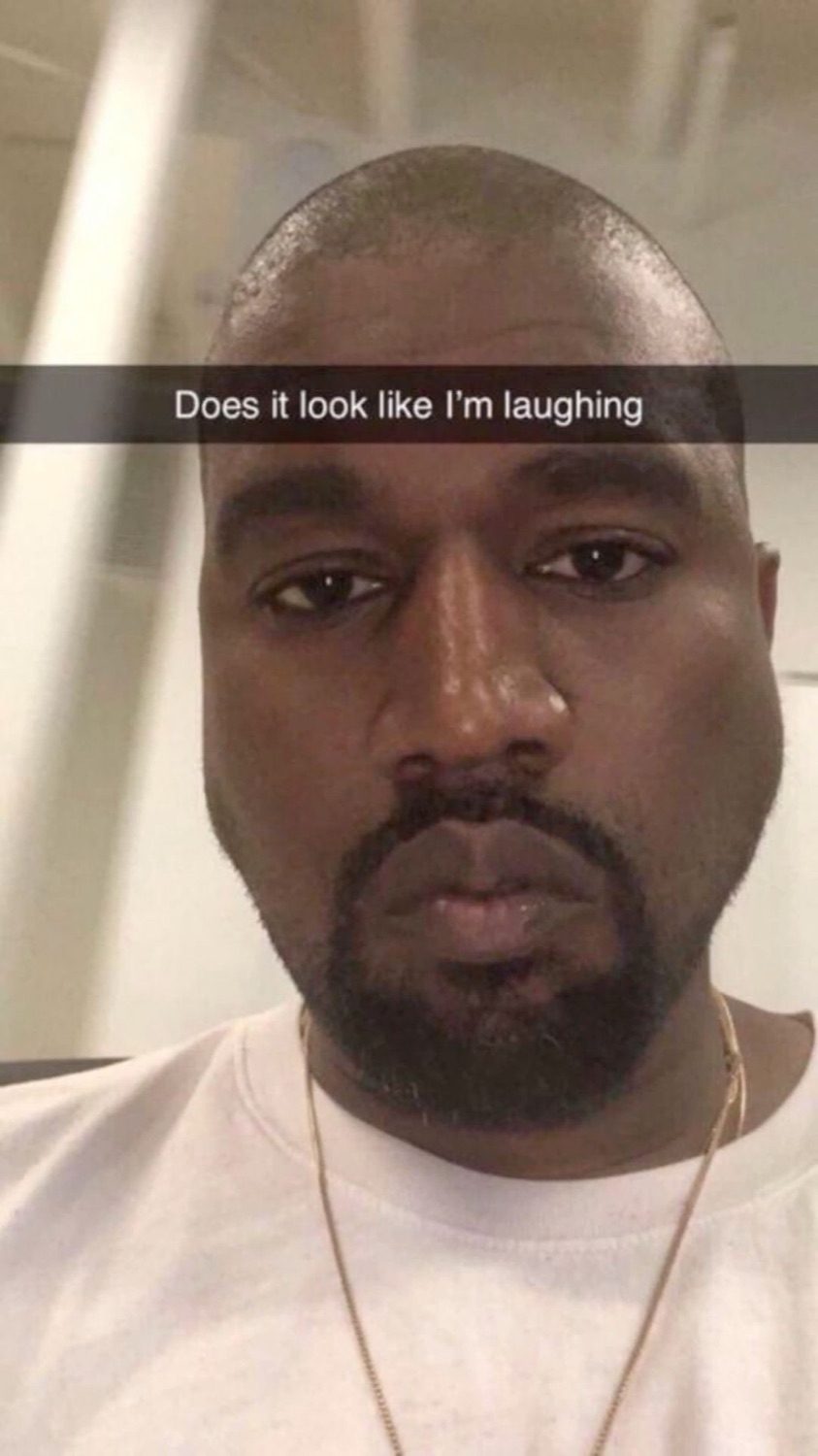 Kanye West selfie with a flat serious face captioned 'Does it look like I'm laughing'