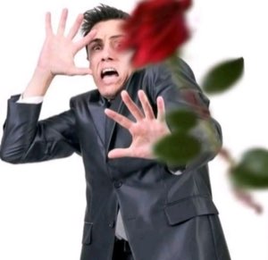 Man in a leather blazer recoiling in horror with hands up as a rose flies at him