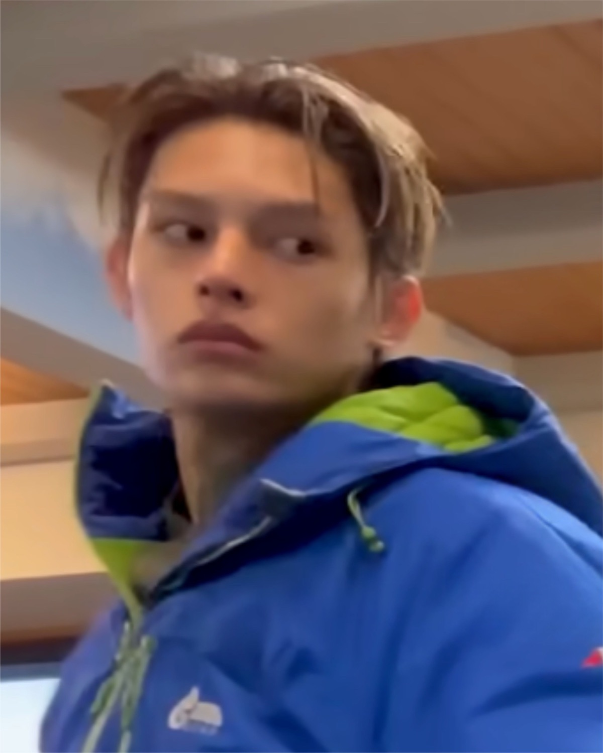Young guy in a blue puffer jacket throwing a suspicious side-eye off camera