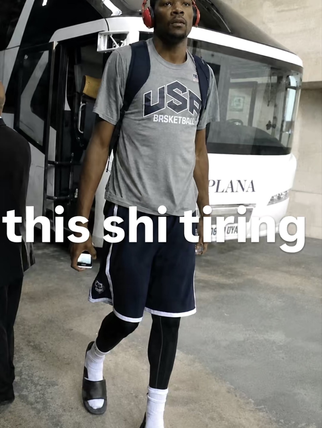 Basketball player in USA gear walking off a bus under 'this shi tiring'