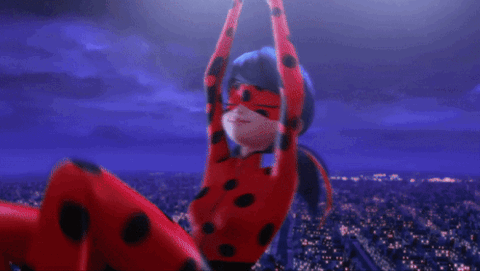 Ladybug from Miraculous posing with a peace sign over Paris at night
