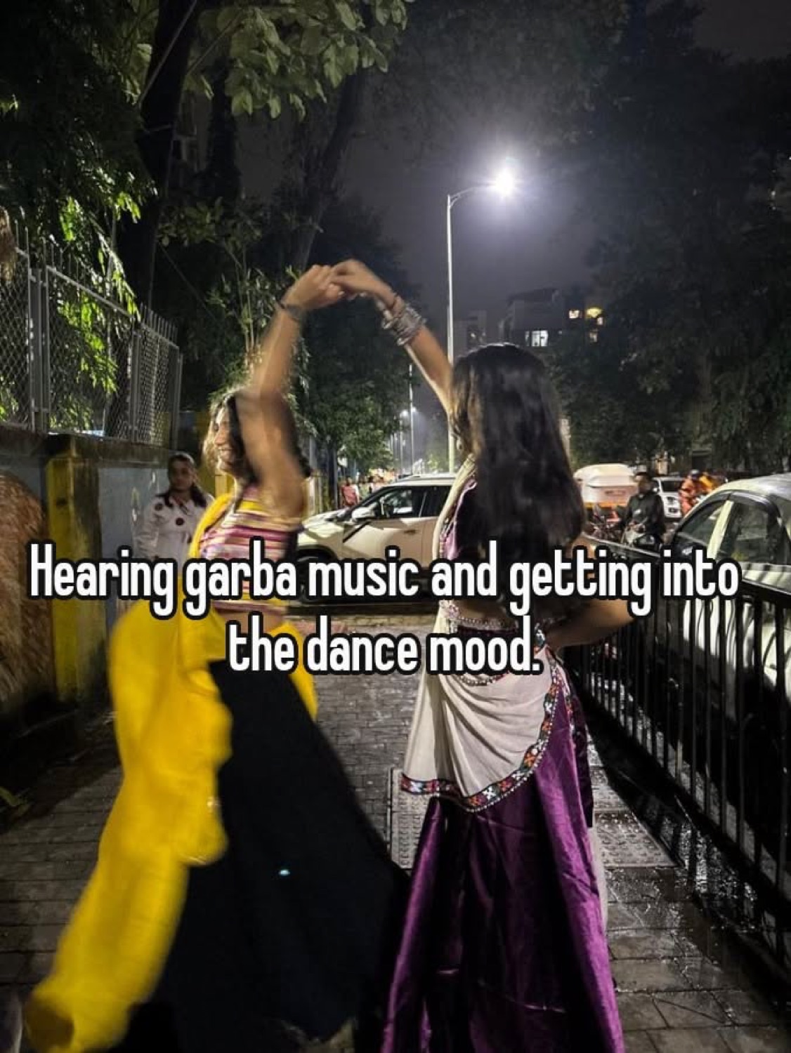 Women dancing on a street at night: 'Hearing garba music and getting into the dance mood'