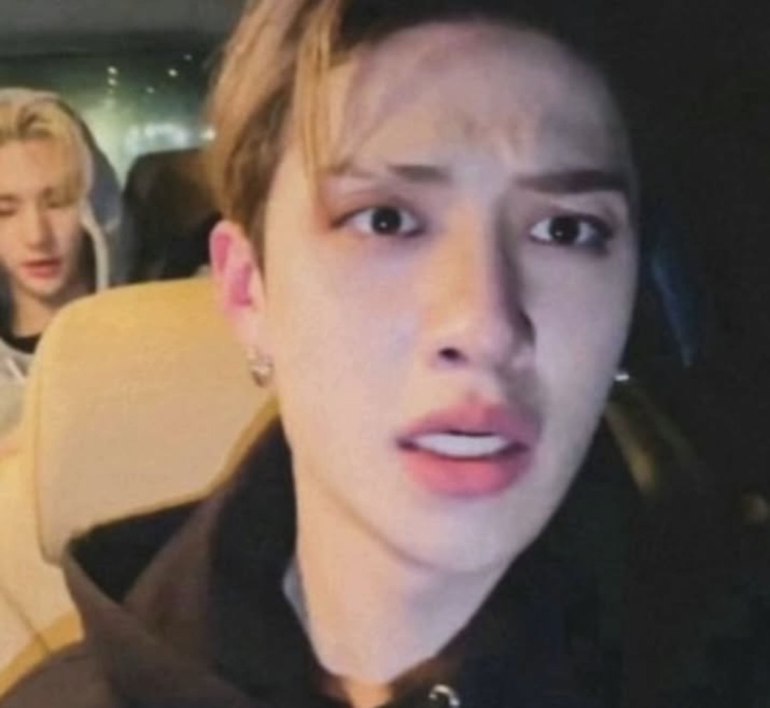 Young man in a car looking confused and slightly disappointed with parted lips