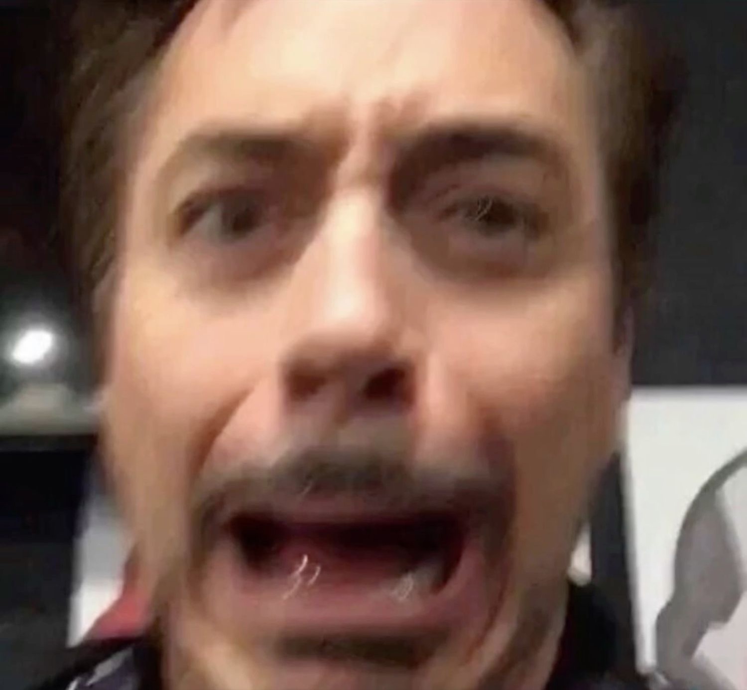 Robert Downey Jr. screaming with mouth agape and eyes wide in total shock