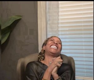 Woman throwing her head back laughing uncontrollably in a leather chair