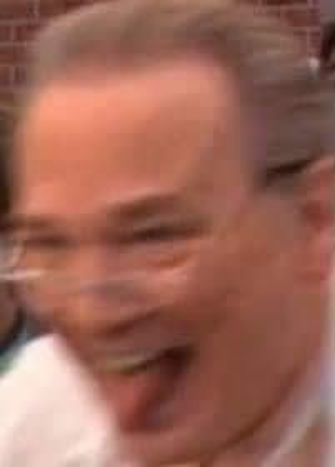Blurry close-up of a man cracking up laughing with his mouth wide open