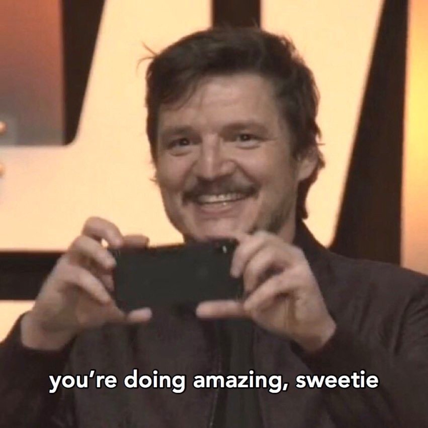 Pedro Pascal beaming and holding up his phone captioned 'you're doing amazing, sweetie'