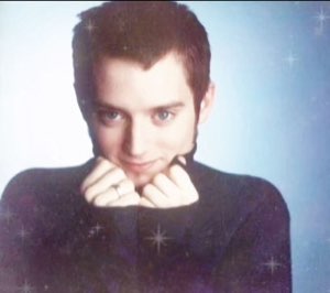 Dreamy sparkle-filtered portrait of a guy resting his chin on both fists