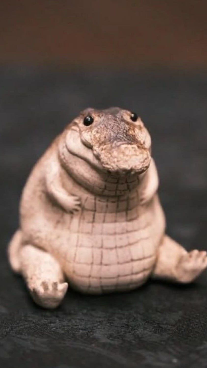 Pink chubby alligator figurine sitting up