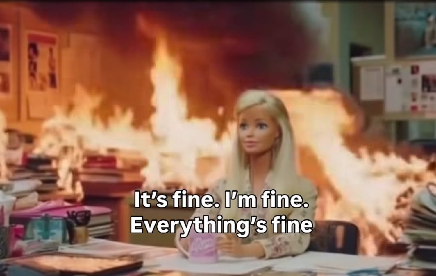 Barbie calmly sitting at a desk in a burning office: 'It's fine. I'm fine. Everything's fine'
