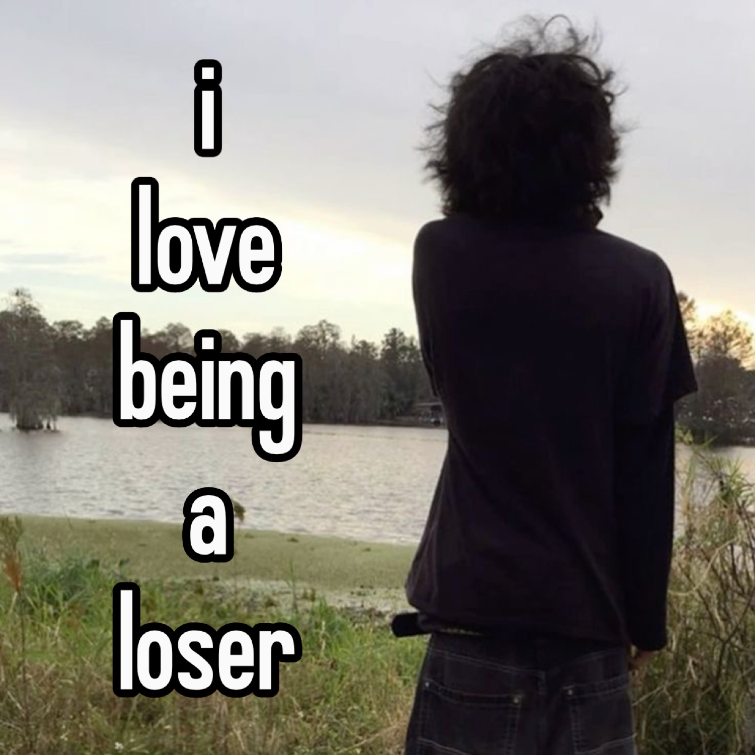 Person with messy hair facing a lake under 'i love being a loser'