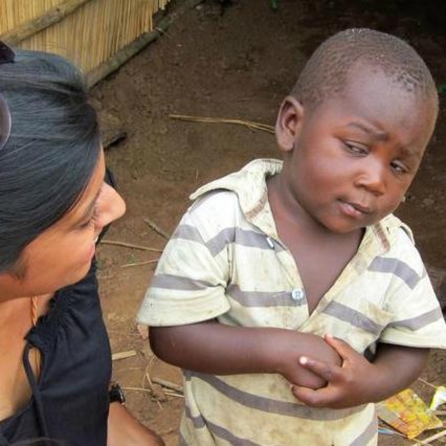 Little kid giving a wary, skeptical side-eye to the woman crouched beside him