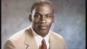 Man in a tan suit smirking confidently at the camera in an old portrait