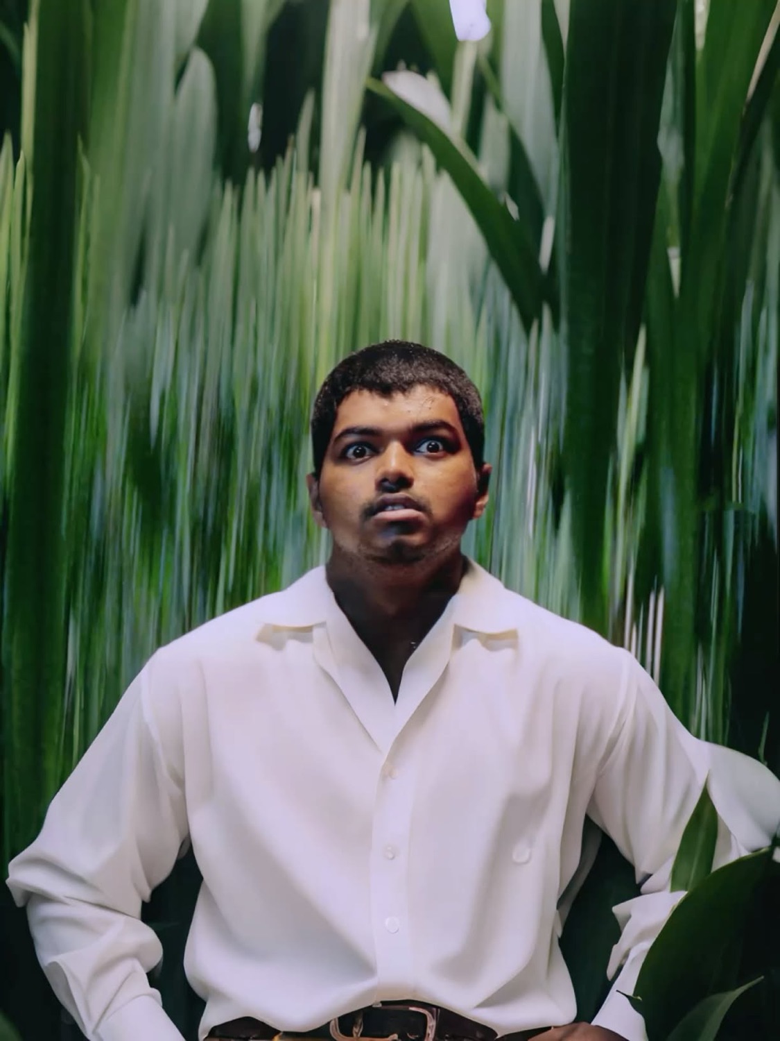 Young Vijay in a white shirt staring with a blank face