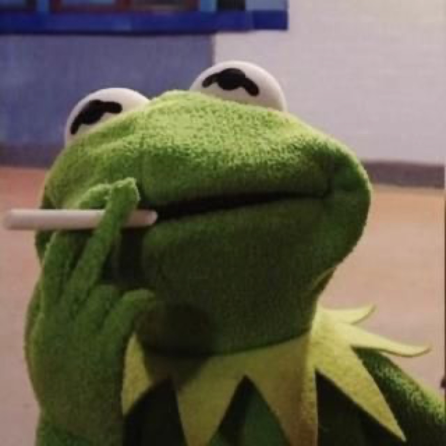 Kermit the Frog staring upward with a straw in his mouth, deep in thought