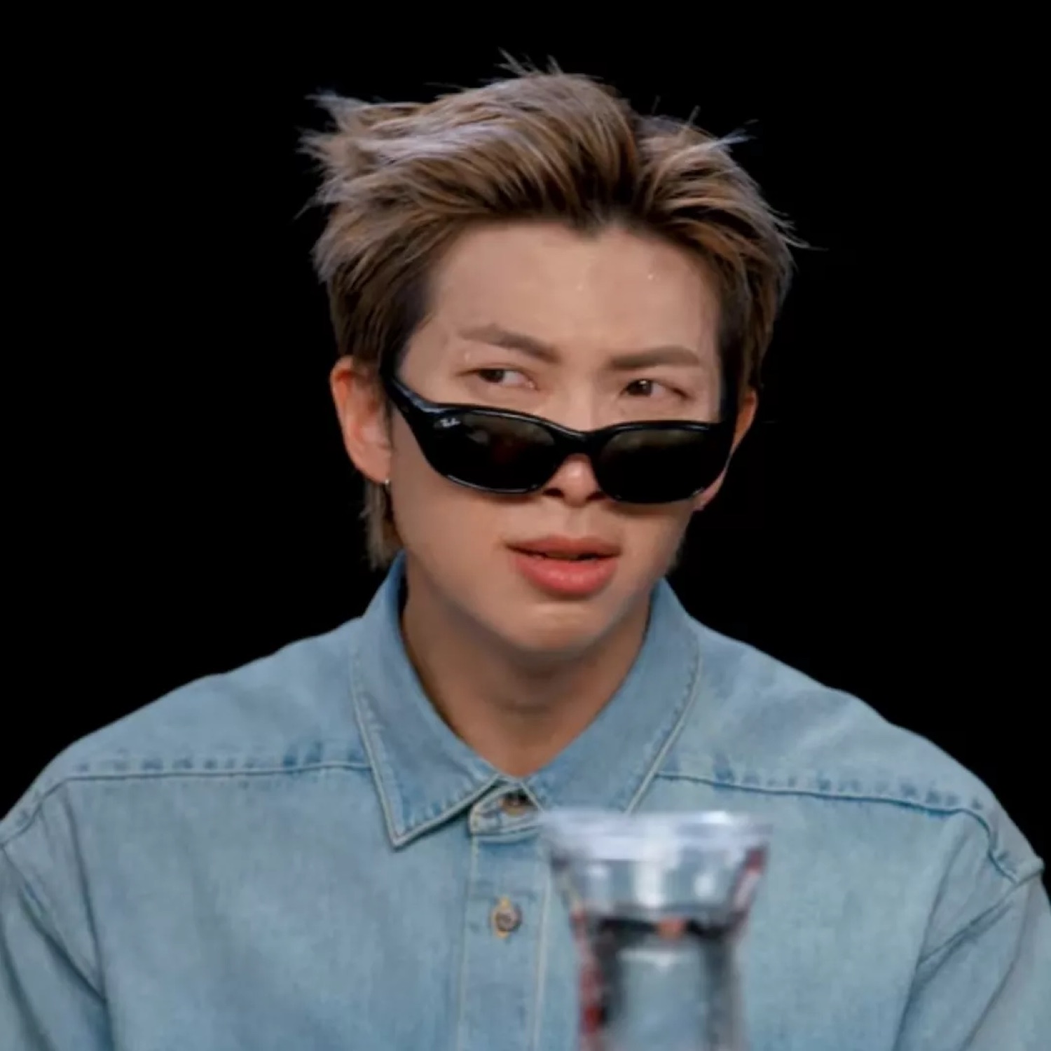 Young person in sunglasses pushed down their nose, delivering a cool side-eye glance