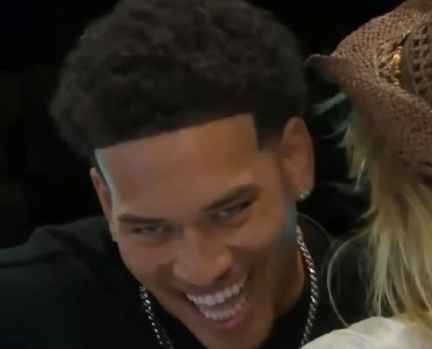 Love Island USA's Corbin grinning with his head down
