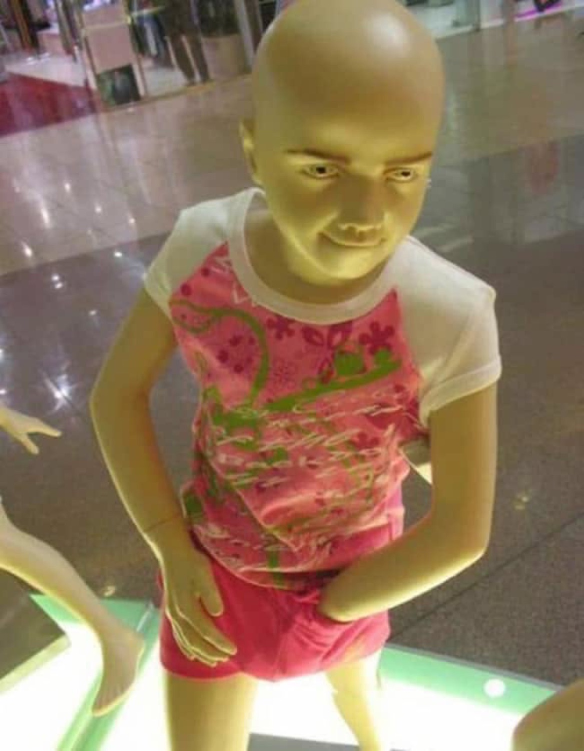 Child mannequin posed hands-on-hips with an unsettlingly smug little smirk