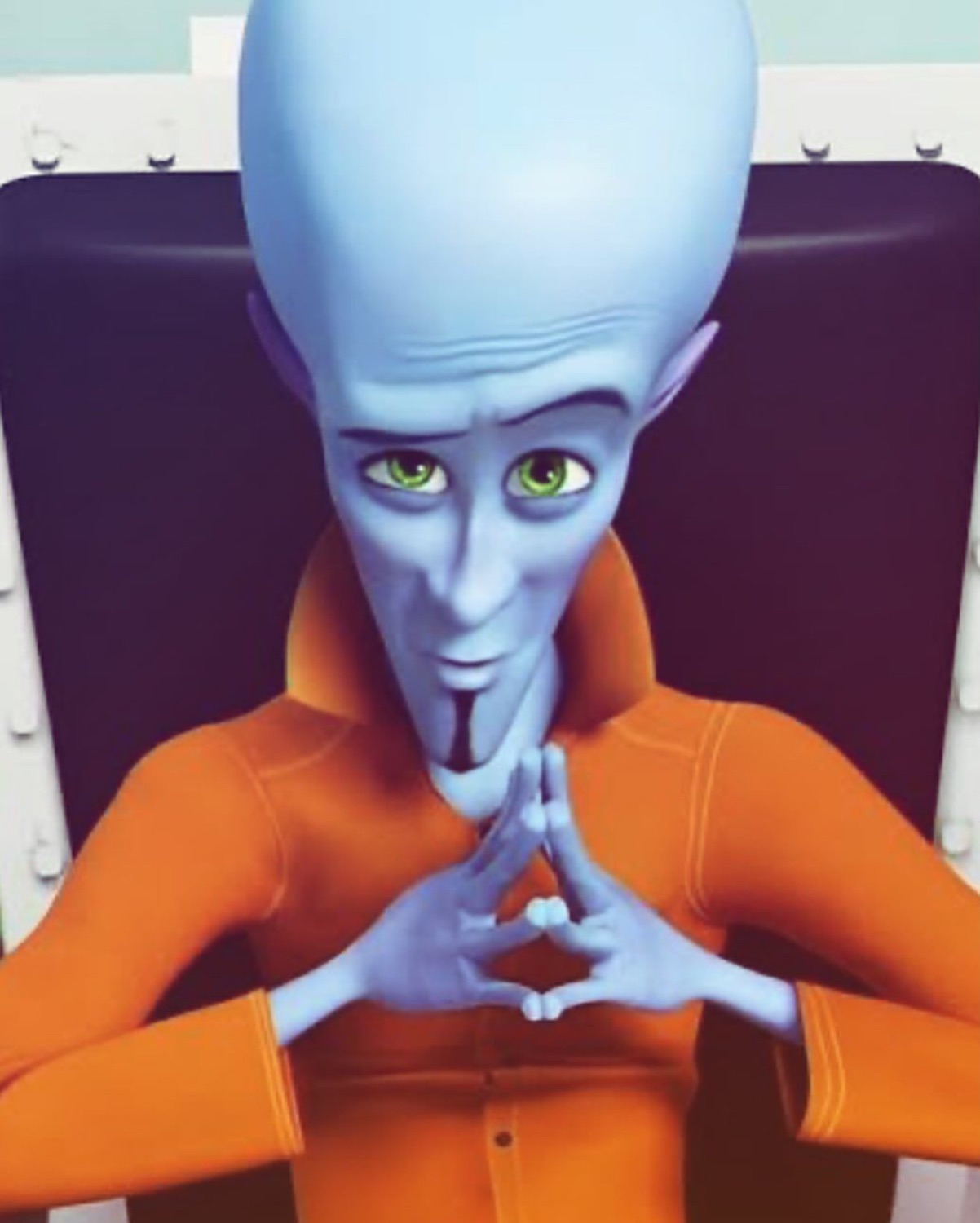 Megamind steepling his fingers with a sly, scheming little smirk