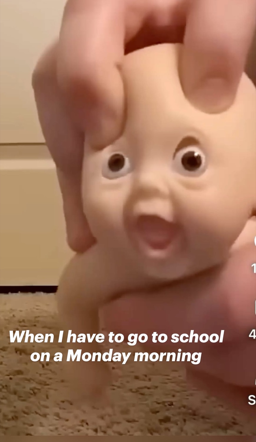 Hand clutching a shocked baby doll's head under 'When I have to go to school on a Monday morning'