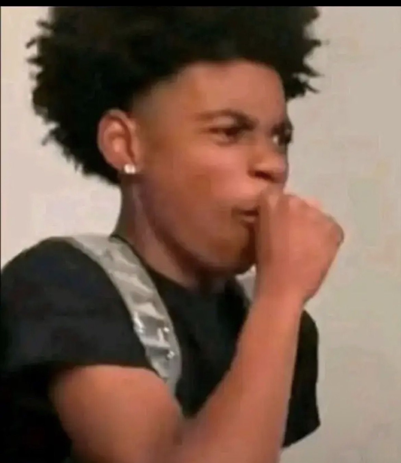 Boy covering his mouth with a fist, gagging