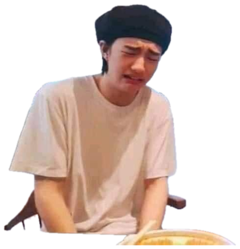 Young man in a beret at a table wincing and crying over his food sticker
