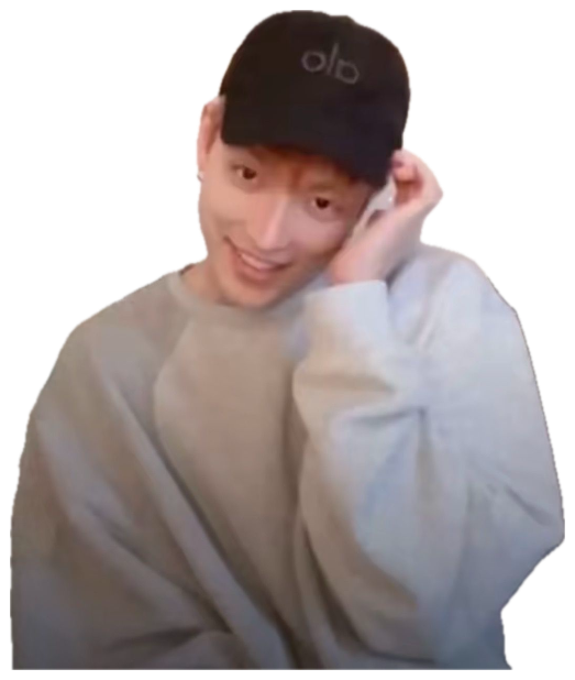 Guy in a black cap smiling shyly with a hand tucked behind his ear sticker