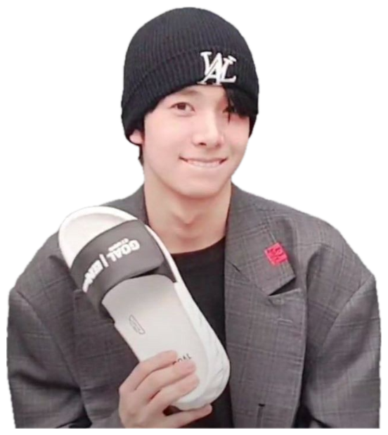 Young man in a black beanie holding up a pair of slides with a shy, pleased smile sticker