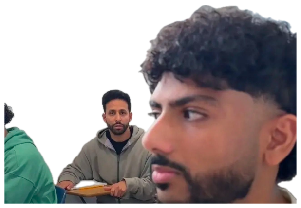Two guys in a classroom, one in the foreground side-eyeing hard while another stares from behind sticker