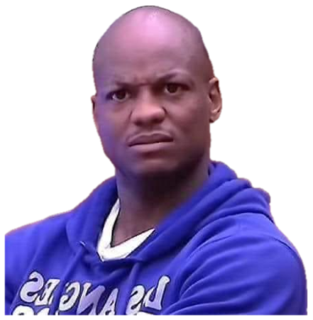 Man in a blue hoodie shooting a skeptical, side-eyeing frown at an office desk sticker