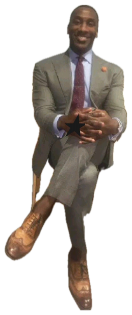 Man in a grey suit lounging cross-legged in a chair with a confident, pleased grin sticker